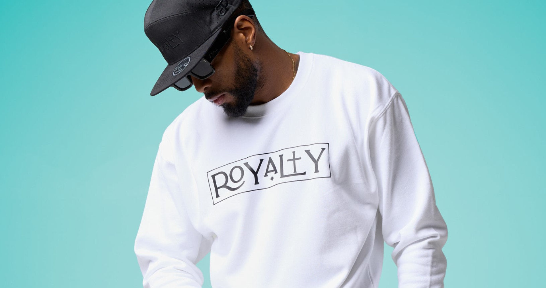 Two women wearing Royalty themed sweatshirts walk confidently down a city street, showcasing urban fashion.